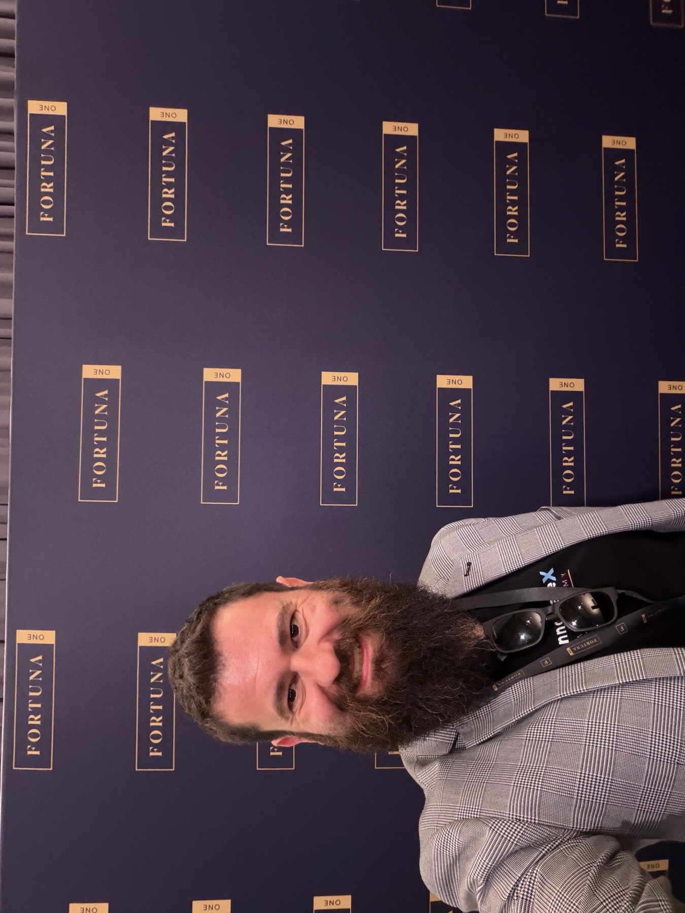 Todd Johnson at the Fortuna One event wall wearing an InnovateX Academy shirt and event lanyard